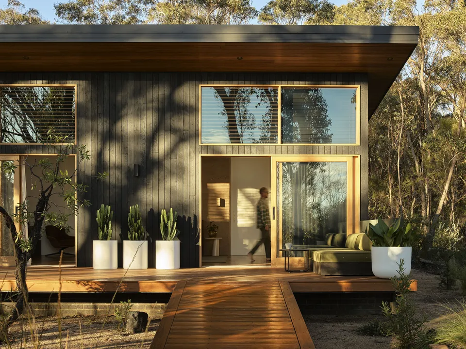 Chalet exterior with timber deck nestled in bushland