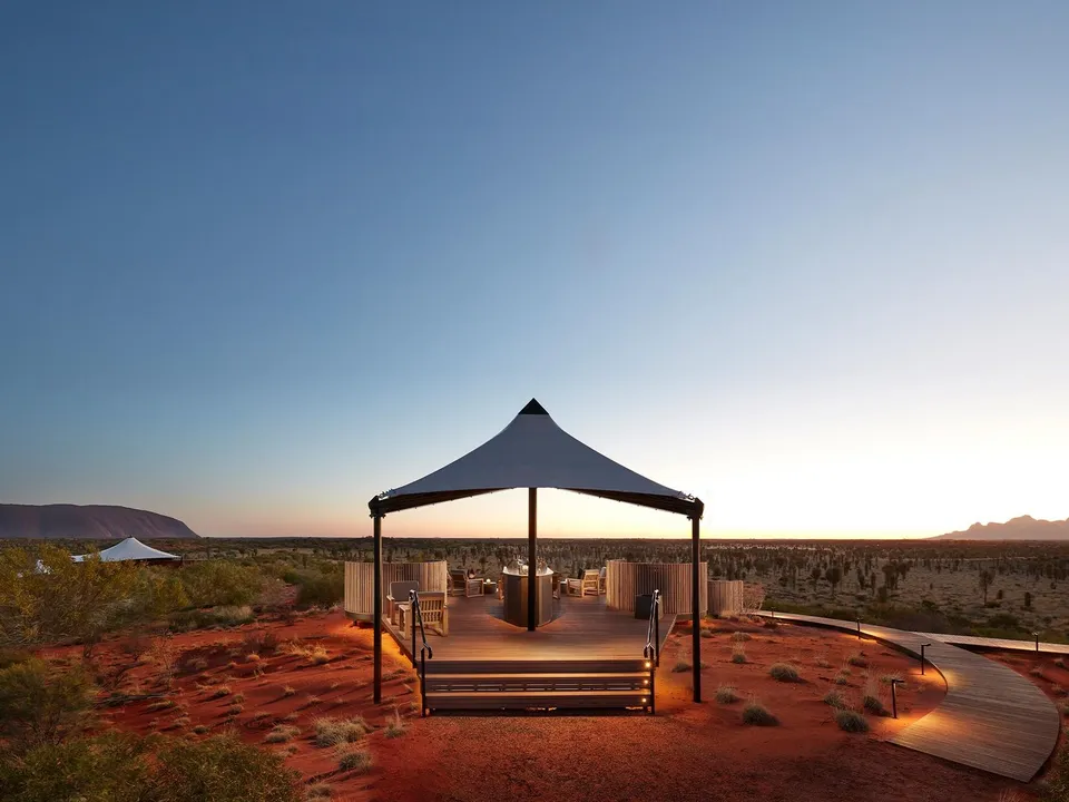 The Dune Pavilion at sunset with Uluru and Kata Tjuta on the horizon