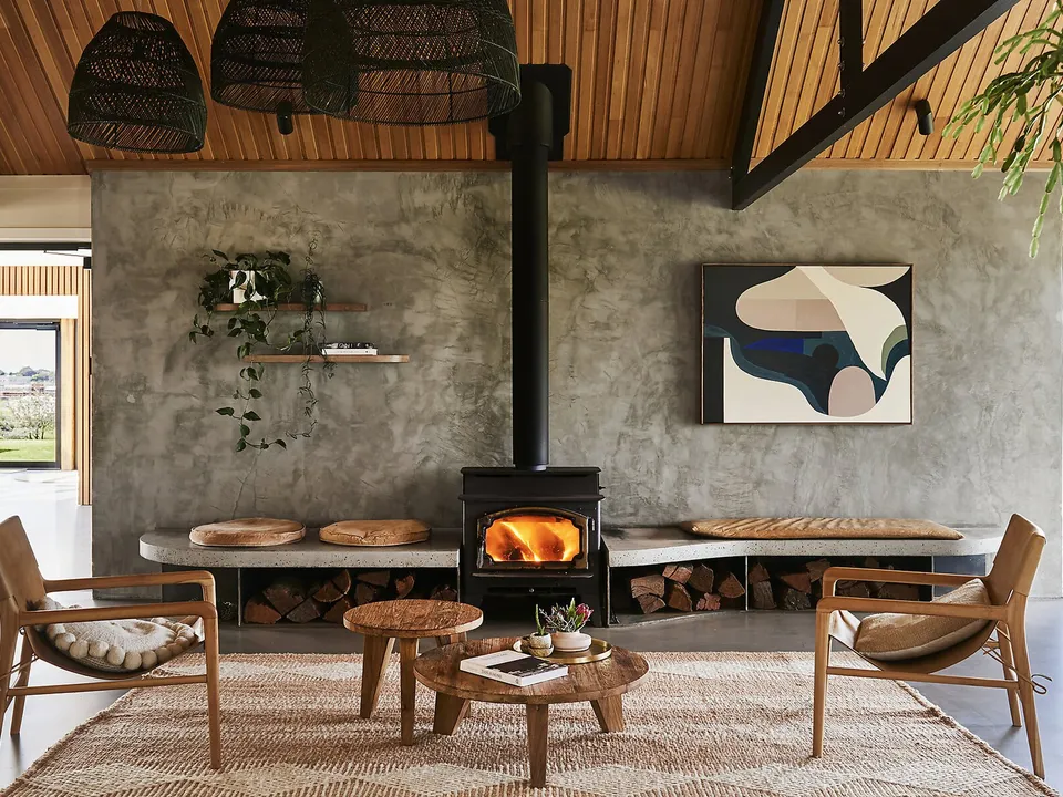 The lounge at Lon Retreat, with crackling fireplace and timber-lined ceiling