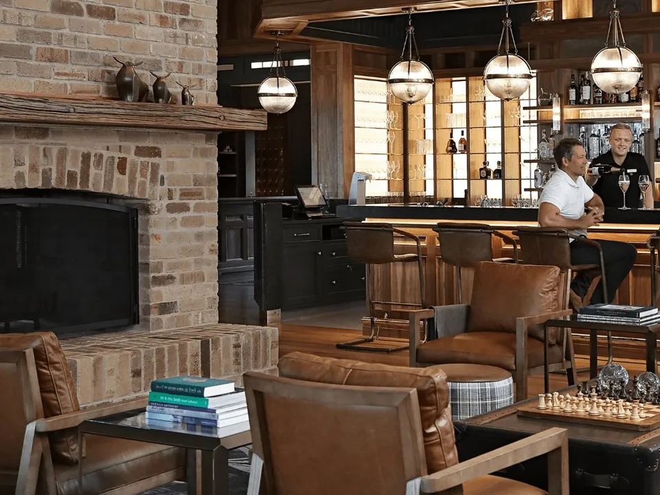 The Homestead bar with brick fireplace and leather armchairs
