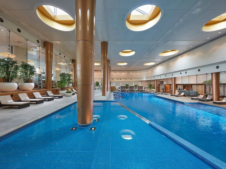 The 25-metre heated indoor pool beneath dramatic skylights and bronze columns