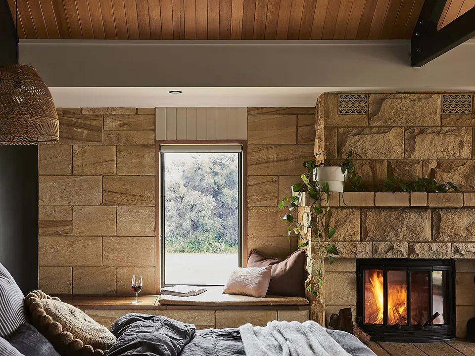 A sandstone-walled suite with fireplace, window seat, and views to the moonah woodland
